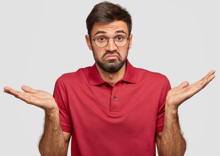Homme avec un t-shirt rouge qui s'interroge sur ce qu'il doit faire